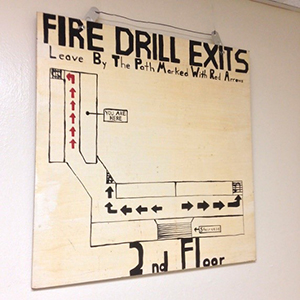 Poster showing arrows and route for safe exits during emergencies or drills