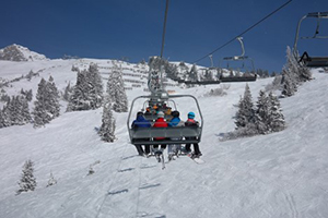 ski lift with passengers going up a mountain in the winter